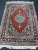 A Persian machine loomed fringed rug on pink ground