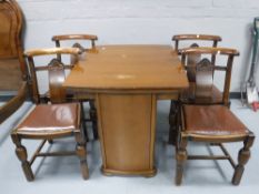 A mid 20th century oak pull out dining table together with four chairs