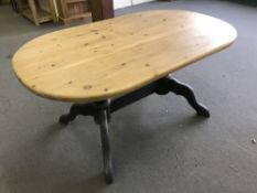 An oval pine kitchen table on painted base