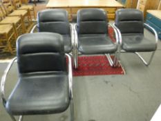 A set of four black leather armchairs with chrome tubular frames