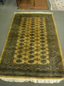 A gold Bokhara design rug