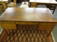 A mid 20th century teak desk fitted seven drawers