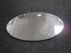 An oval unframed mirror