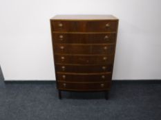 A mid 20th century bow-fronted teak seven drawer chest