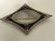 A diamond and jet brooch set with four cabochon rubies
