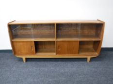 A mid 20th century teak sliding door bookcase