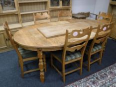 A mid 20th century blonde oak extending dining table with two leaves and six chairs