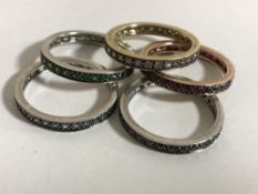 A suite, or stack, of five 9ct gold eternity rings, each set rubies, sapphires, emeralds,
