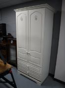 A contemporary double door wardrobe fitted two drawers in a cream finish