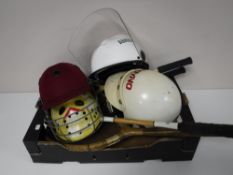 A box containing dart board, tennis rackets, cricket helmets, archery bow,