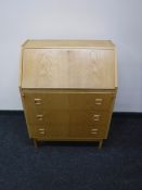 A mid 20th century blond oak bureau
