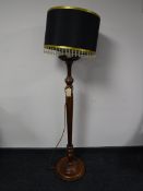 A carved mahogany standard lamp and shade