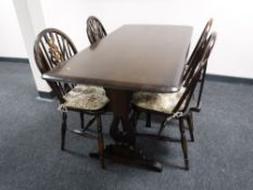 An Ercol refectory dining table together with four wheel back chairs
