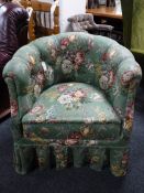 An early 20th century tub chair upholstered in a green floral fabric