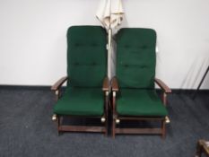 A pair of plantation teak reclining garden armchairs with cushions and a parasol