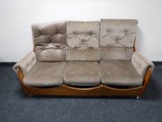 A mid 20th century teak framed saddle suite in brown fabric