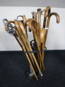 A cast iron stick stand, containing a quantity of walking sticks,