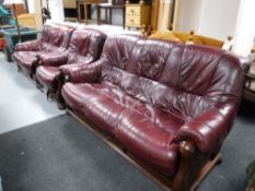 A three piece wood framed Burgundy leather lounge suite, comprising of three seater settee,