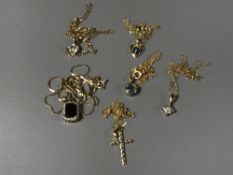 Six 9ct gold necklaces and pendants - one set with blue sapphire and diamonds.