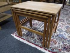 A nest of three 20th century blonde oak tables