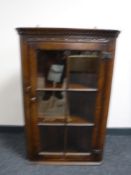An oak glazed door hanging corner cupboard