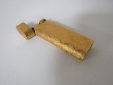 A Cartier gold plated cigarette lighter in a textured bark finish