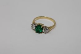 An 18ct gold emerald and diamond three stone ring,