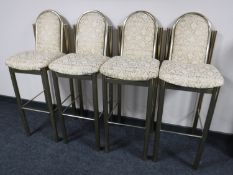 A set of four brass upholstered bar stools