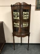 A pair of mahogany glazed bow fronted cabinets on stands ' Fry's Milk Chocolate', height 165 cm.