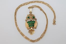 An 18ct owl pendant set with emerald and chain. 12.