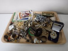 A tray containing costume jewellery, rugby medal, sterling silver napkin ring etc