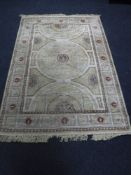 A machine made rug of Indian design, on beige ground,
