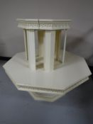 An octagonal white coffee table and a nest of two tables