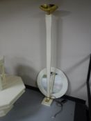 A white and brass up-lighter and a circular white framed mirror