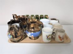A tray containing late 19th and early 20th century commemorative mugs, four copper lustre jugs,