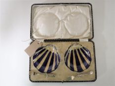 A pair of cased glass oyster dishes with silver forks