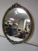 An early twentieth century ornate oval gilt framed mirror
