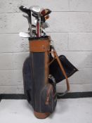 A golf bag containing a quantity of assorted drivers,