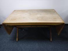 A continental oak drop end dining table on X frame supports