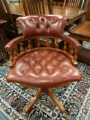 A chesterfield style buttoned burgundy leather captain's chair,