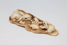 A well-carved Japanese ivory netsuke depicting a family of rabbits, Meiji period,