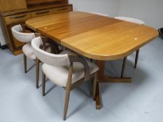 A mid 20th century teak extending dining table with two leaves and four elbow chairs