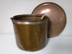 A large antique copper cooking pot with associated lid