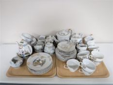 Two trays of two Japanese tea services one with an image of a Geisha