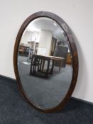 A large oval Edwardian oak framed bevel edged mirror