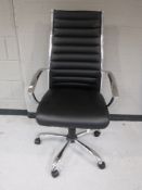 A chrome framed black leather high backed swivel office armchair