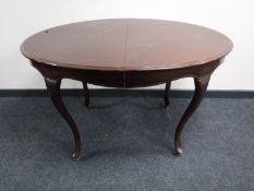 An oval mahogany extending dining table on cabriole legs,