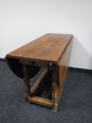 An oak gate leg table fitted a drawer