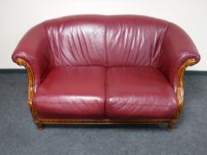 A Burgundy leather scroll arm two seater settee
