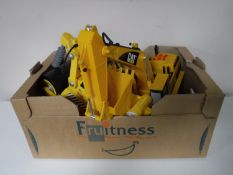 Two boxes containing large scale plastic Caterpillar trucks, Megablox building bricks,